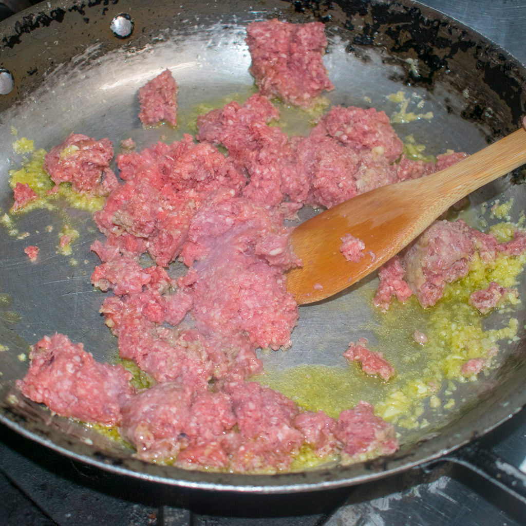 Once skillet is hot add the olive oil, ground beef, garlic, ginger, and a pinch of salt