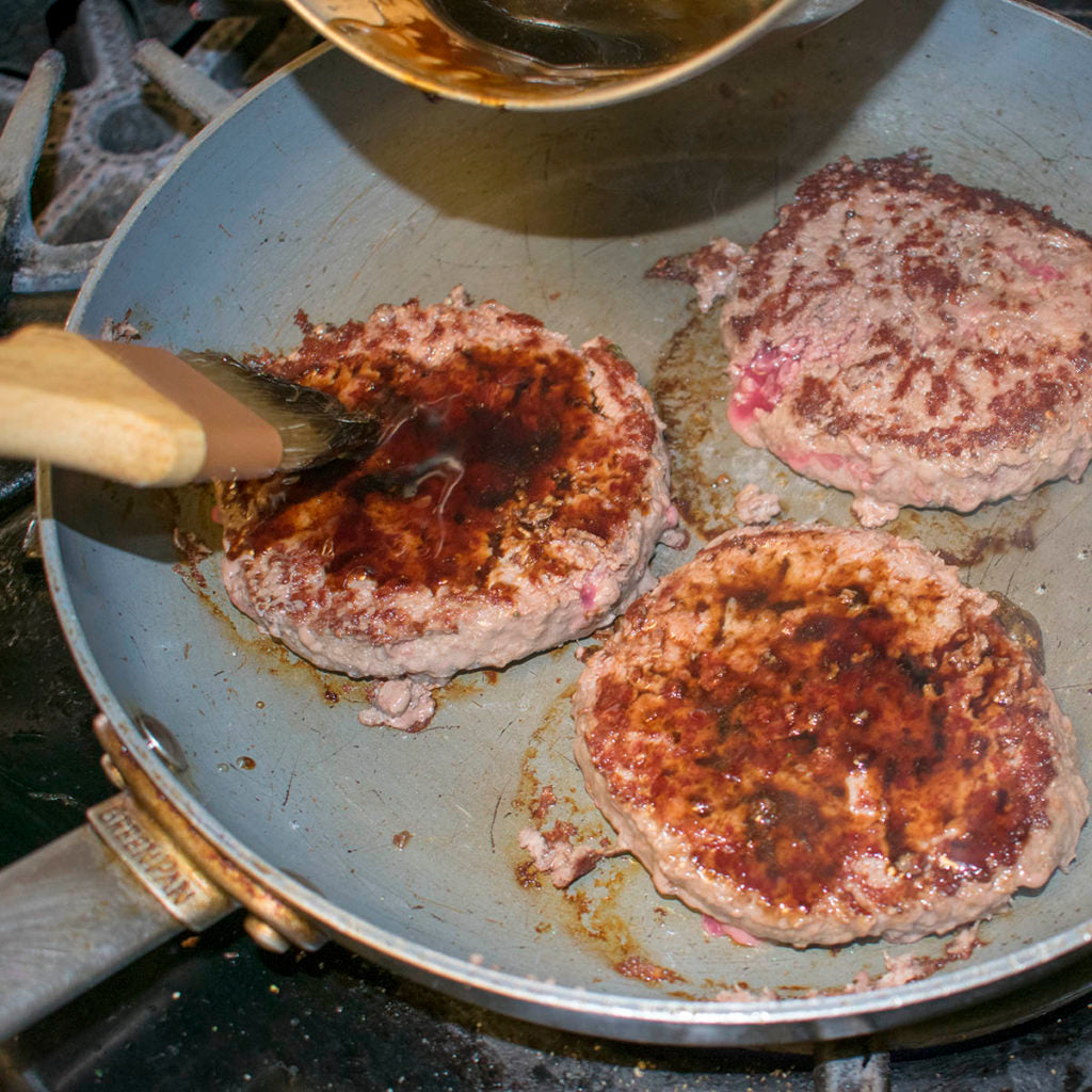 Grill the burgers until golden brown on one side then turn and brush with balsamic reduction