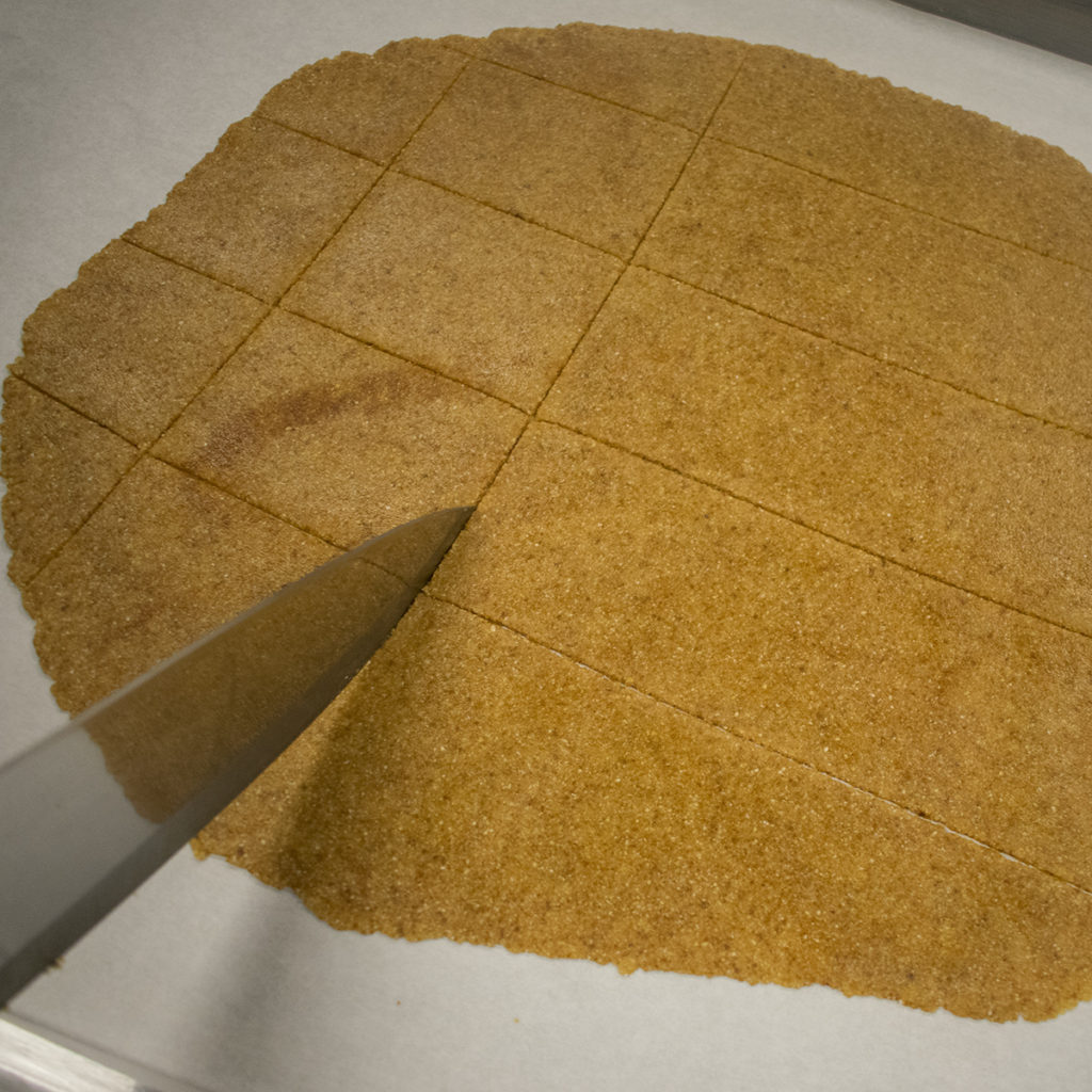 Cut the rolled out dough into crackers using a pizza cutter or knife