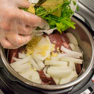 Add bay leaves, parsley, thyme, onion, and garlic into the instant pot