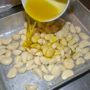 Pour olive oil over garlic cloves