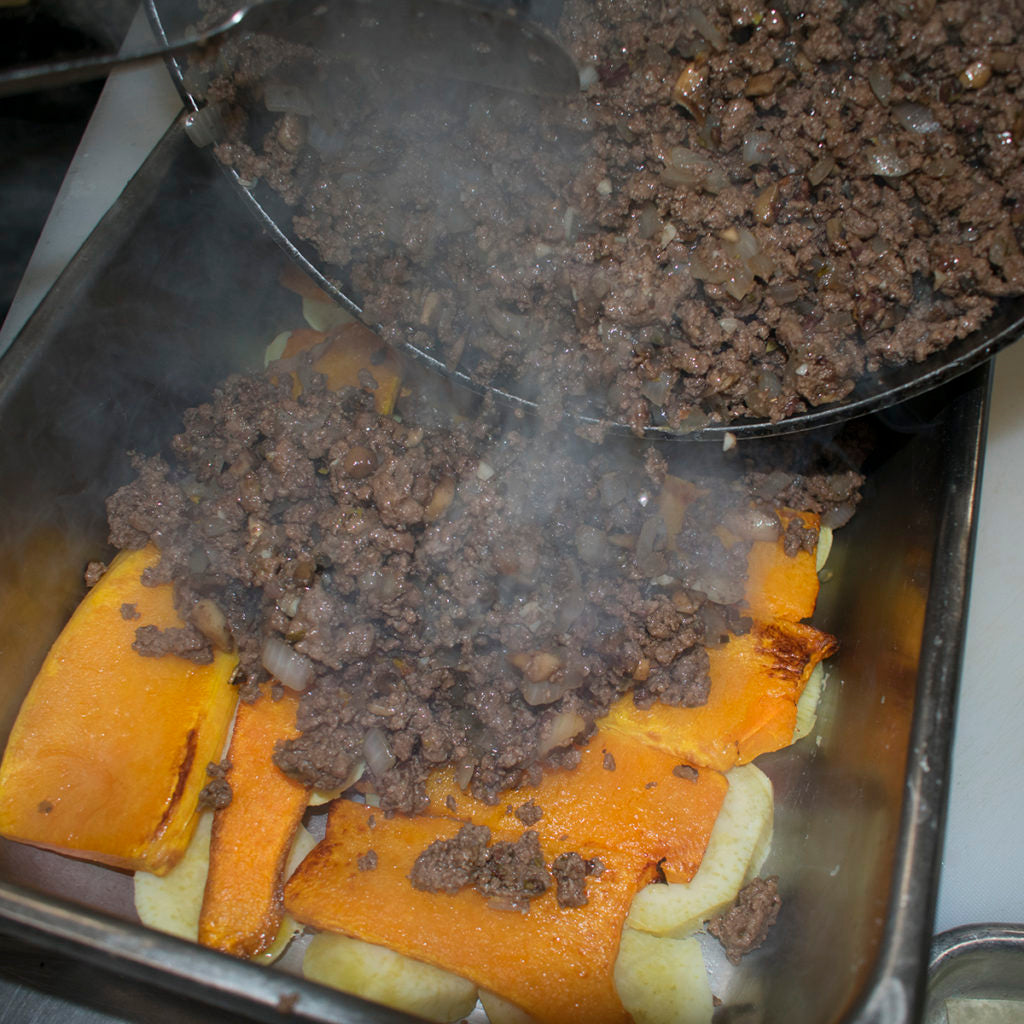 Top the potatoes with a layer of squash slices and cover with the meat sauce
