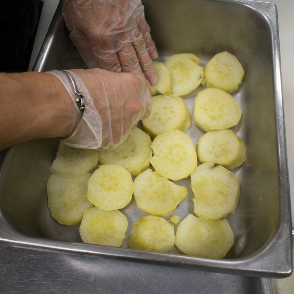 To assemble the dish, layer the bottom of a casserole with the potatoes overlapping slightly.