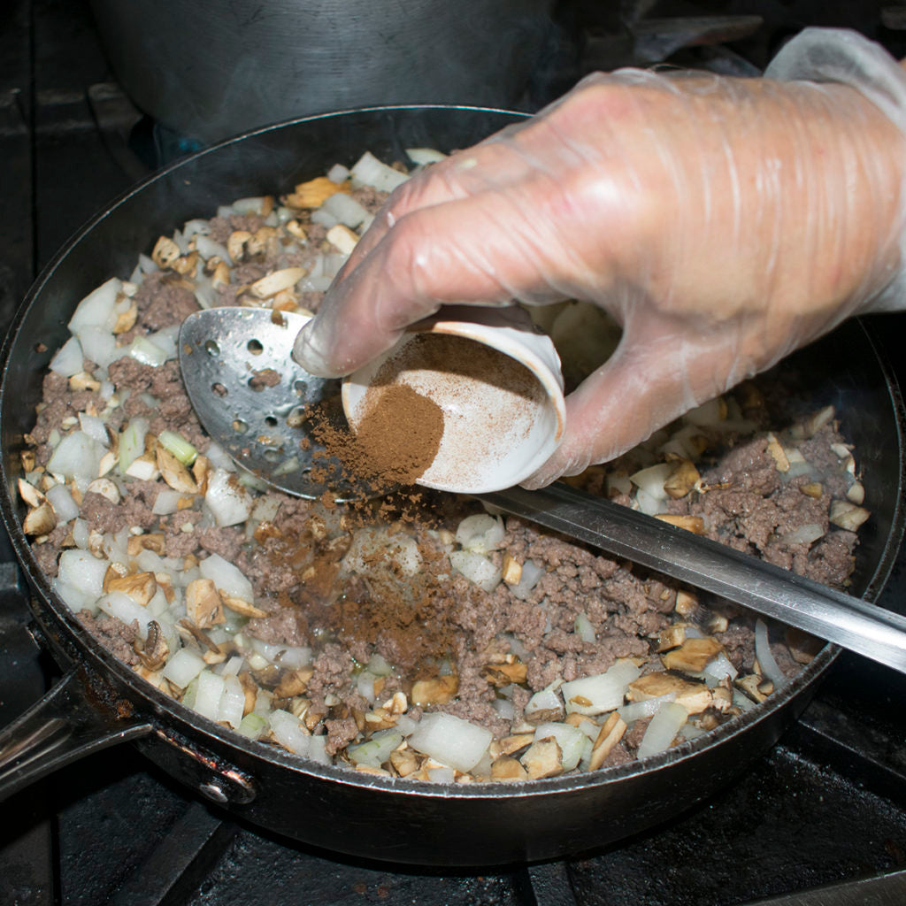 Once the meat is browned and onions have softened, pour in cinnamon