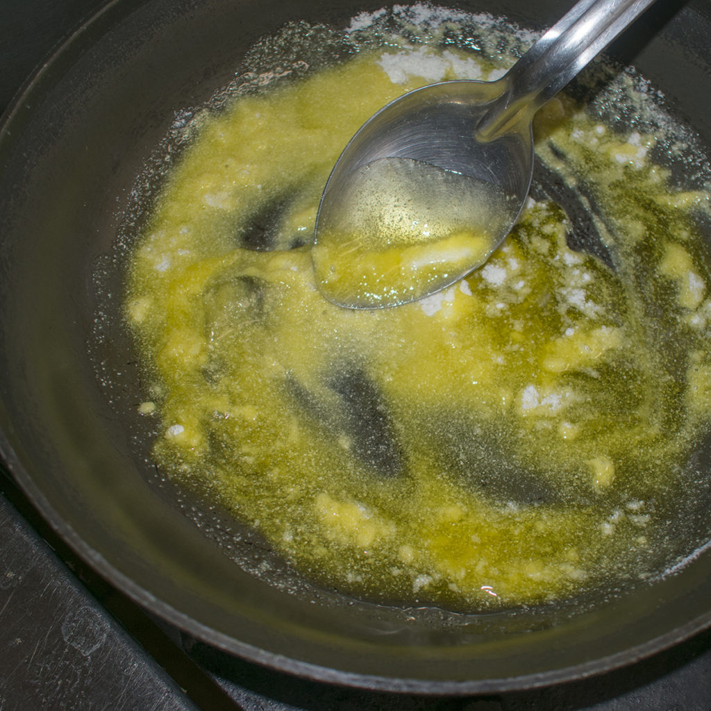 Wisk flour and olive oil together to make a roux