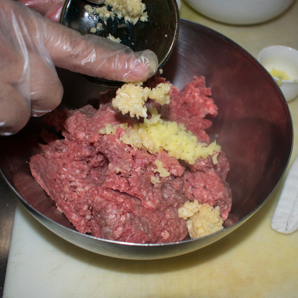 put aip ground beef in bowl and add minced garlic and ginger