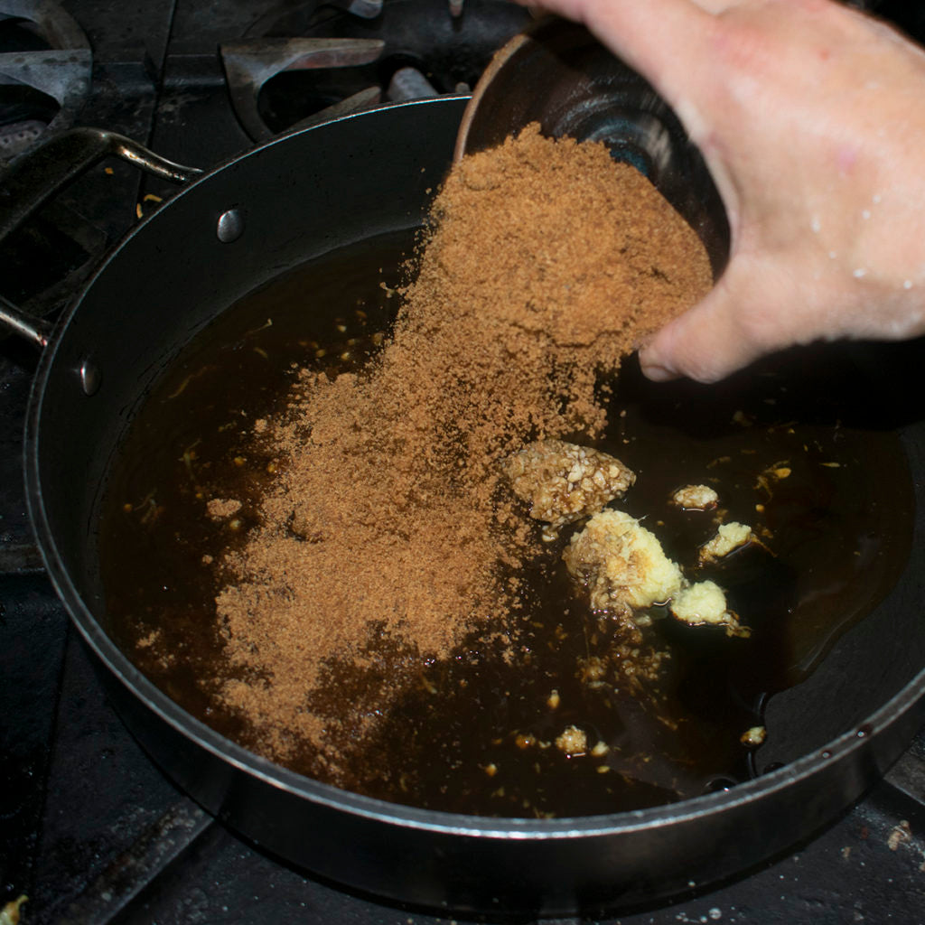 in a non stick skillet mix together minced garlic, coconut sugar, molasses, water, and apple cider vinegar