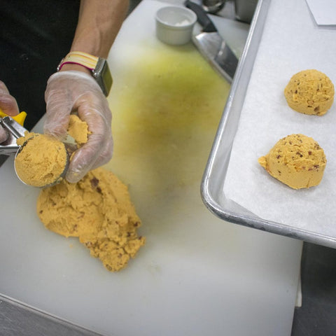Use a biscuit cutter to cut out the biscuits and transfer to the sheet tray.