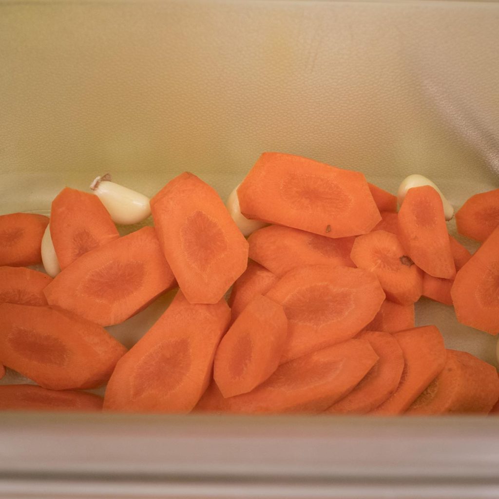 Layer garlic and carrots in a jar