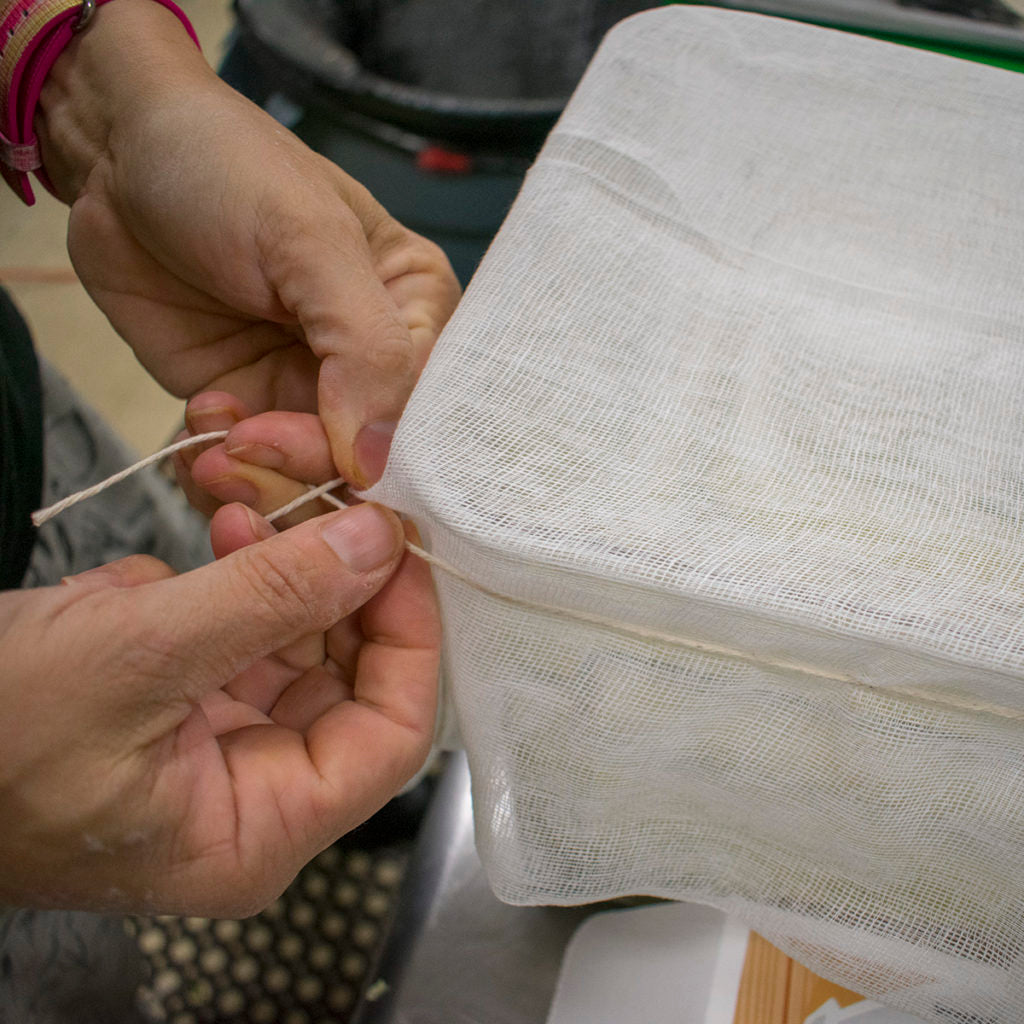 Cover the mouth of the mason jar with a piece of cheesecloth and secure it with a rubber band or twine.