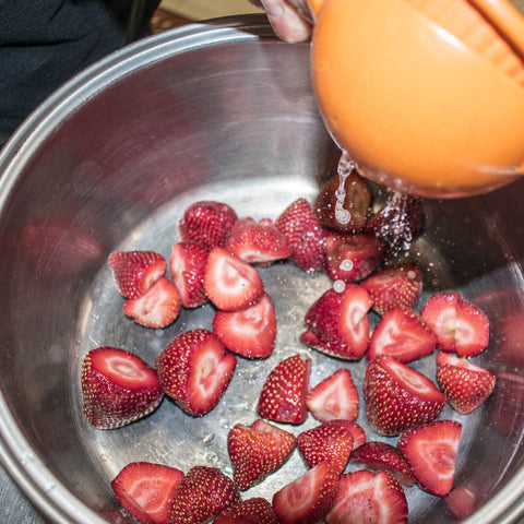 place sliced strawberries and lemon juice in pan