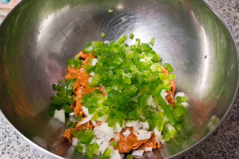 combine the chorizo, onions, bell peppers and pork skins and mix by hand