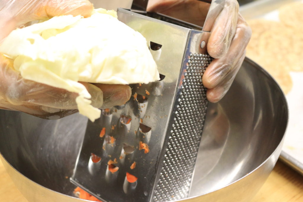 Shred the cabbage into a mixing bowl