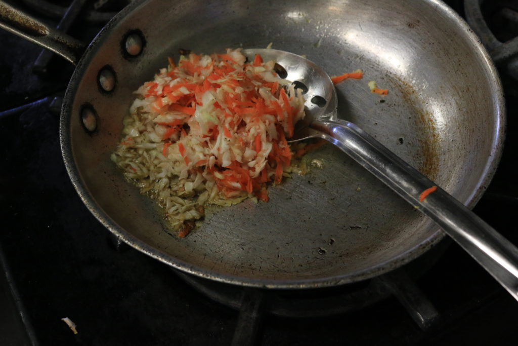 Saute shredded cabbage and carrots until wilted