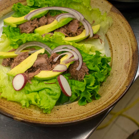 butter lettuce leaf topped with lingua avocado cilantro red onions radishes and lime juice