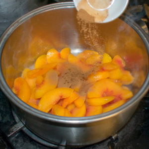 Pour in arrowroot with the peaches and honey in the saucepan