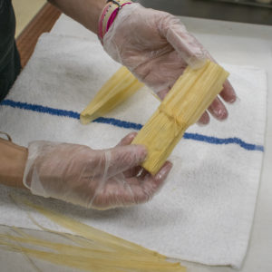 Tie the rolled tamales closed with the string to hold them together