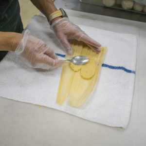 Spread a tablespoon or two of plantain mixture over the top of the husk in the center