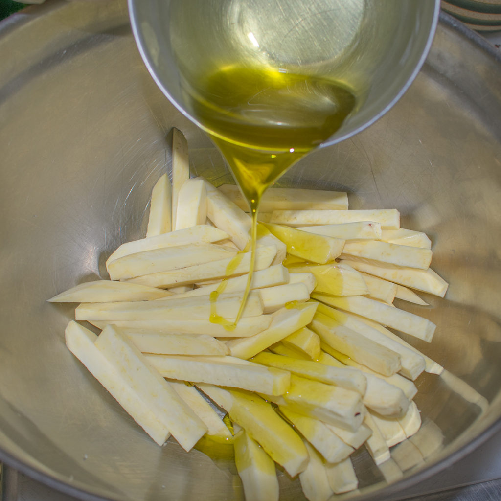Peel and cut potatoes into French fry shaped sticks and drizzle with olive oil