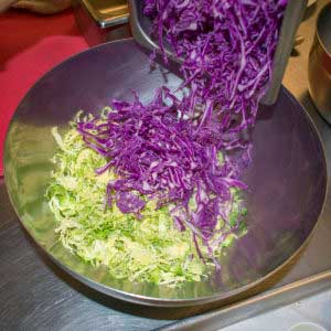 Combine shredded brussels sprouts, cabbage and carrots in a bowl.