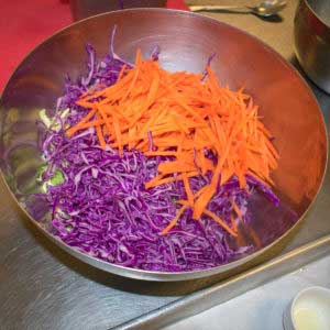 Combine shredded brussels sprouts, cabbage and carrots in a bowl.