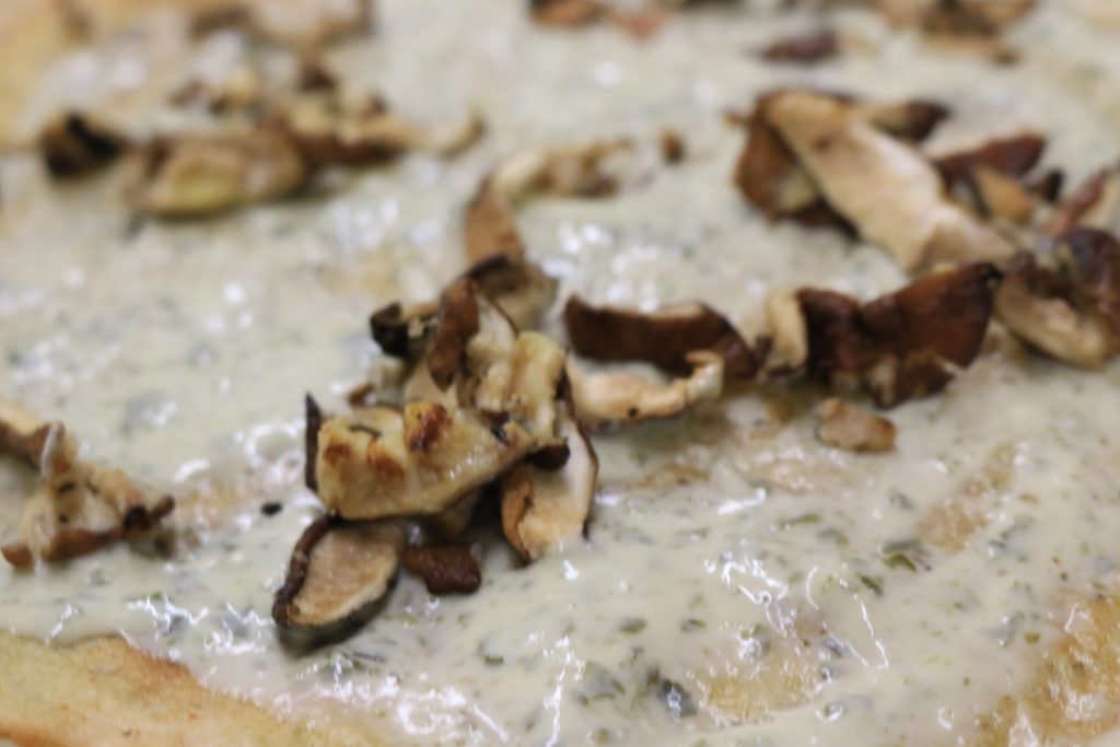 Spread pesto over the surface of the crust