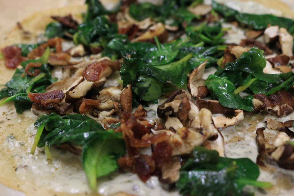 Sprinkle toppings evenly over the pizza